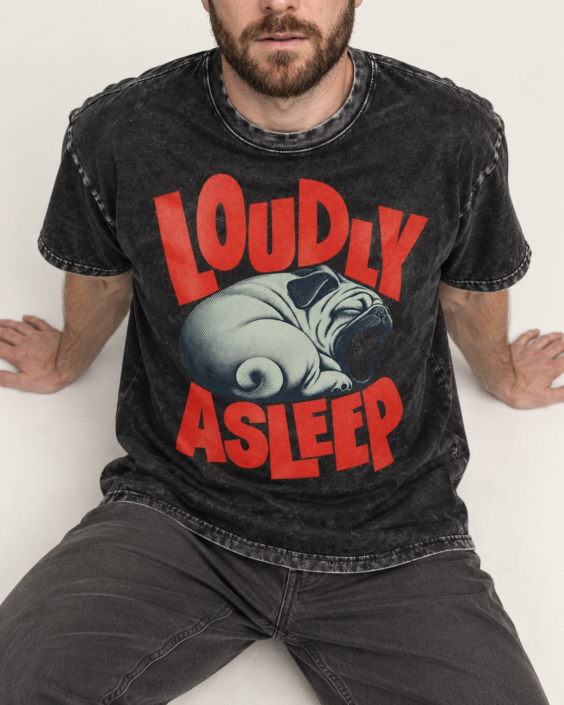 Pug Loudly Asleep Curled Yawn Graphic Washed Tee in Black, worn by a seated model