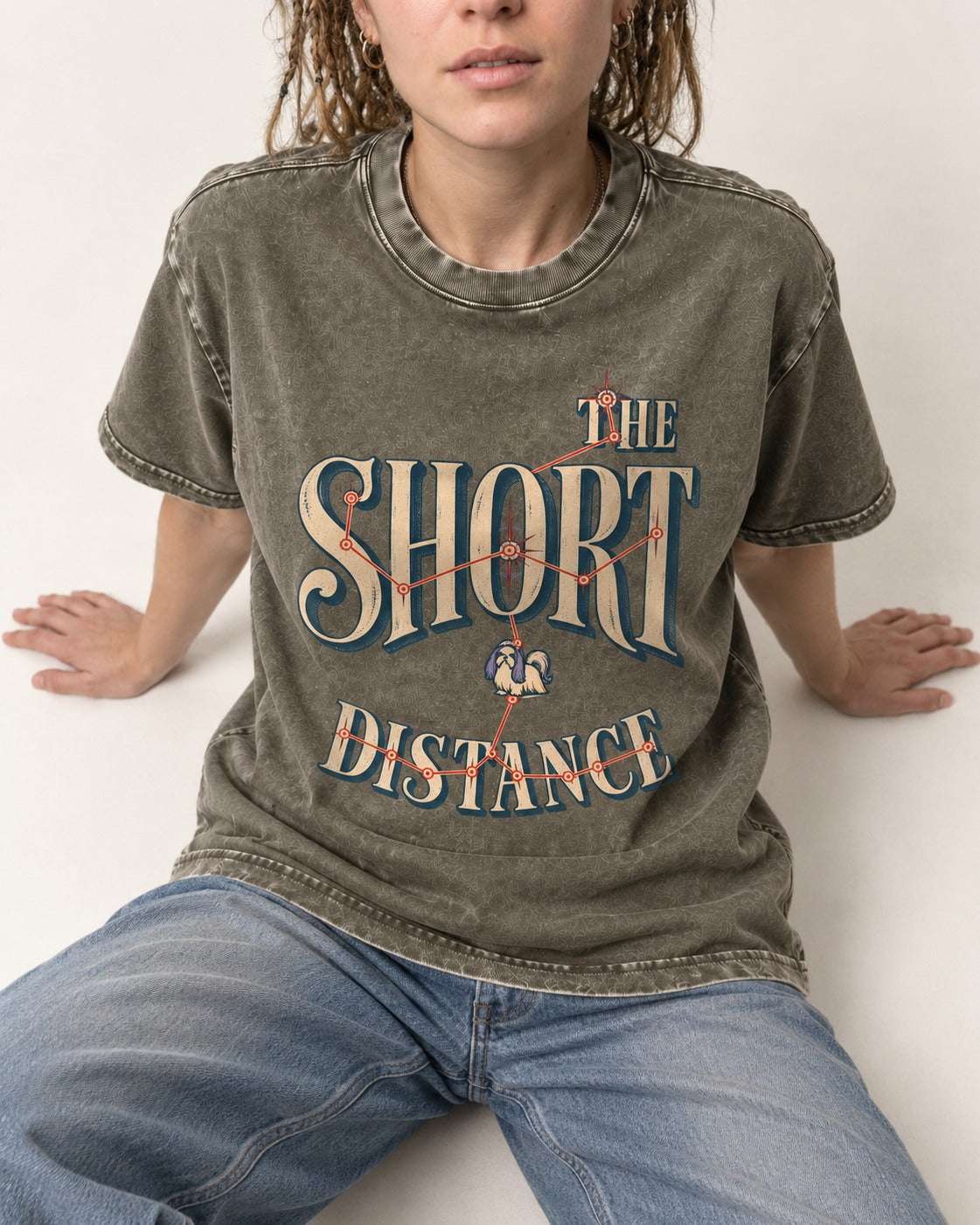 Shih Tzu The Short Distance Route Graphic Washed Tee in Army Green, worn by a seated model