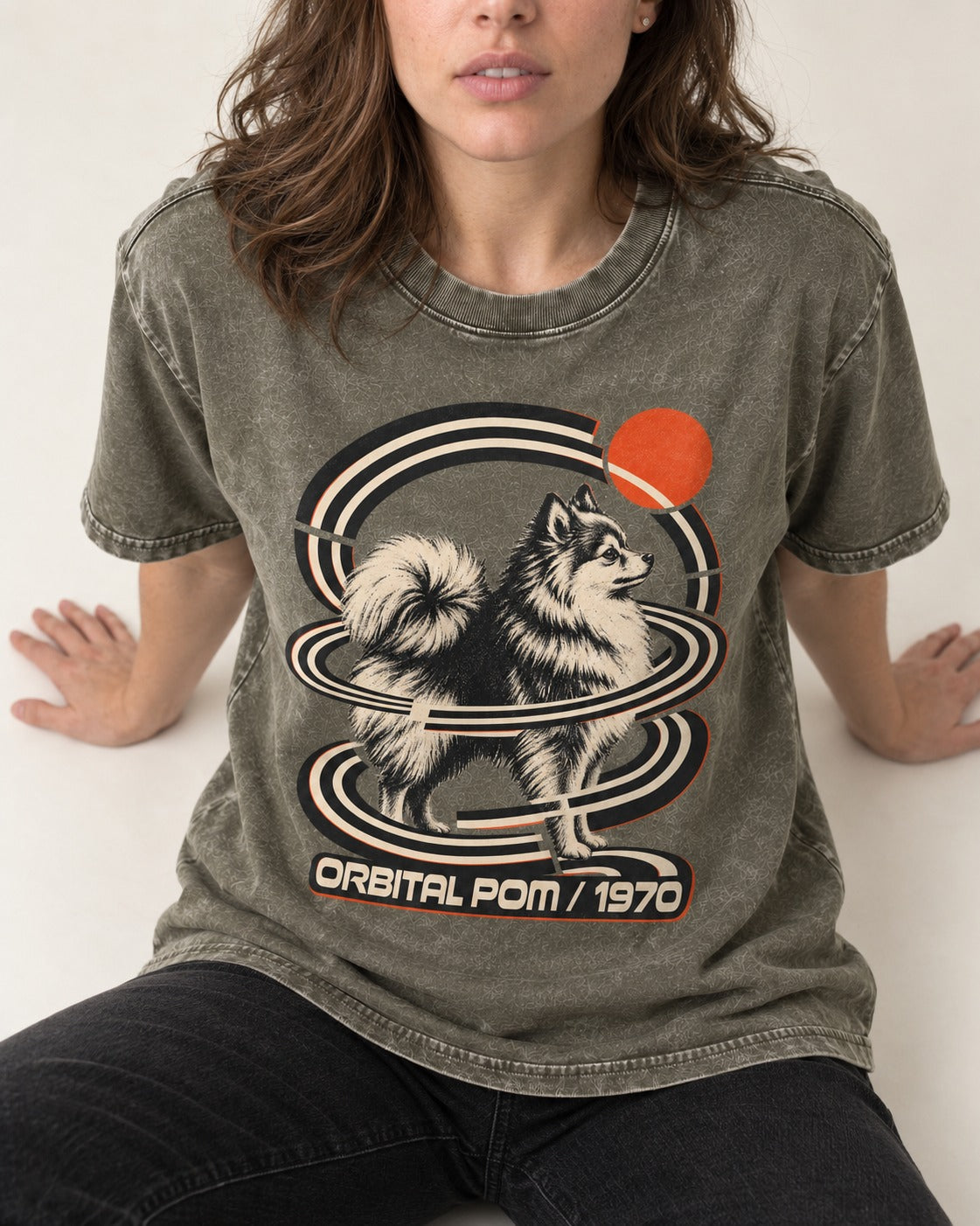 Pomeranian Orbital Pom 1970 Space Age Graphic Washed Tee in Army Green, worn by a seated model