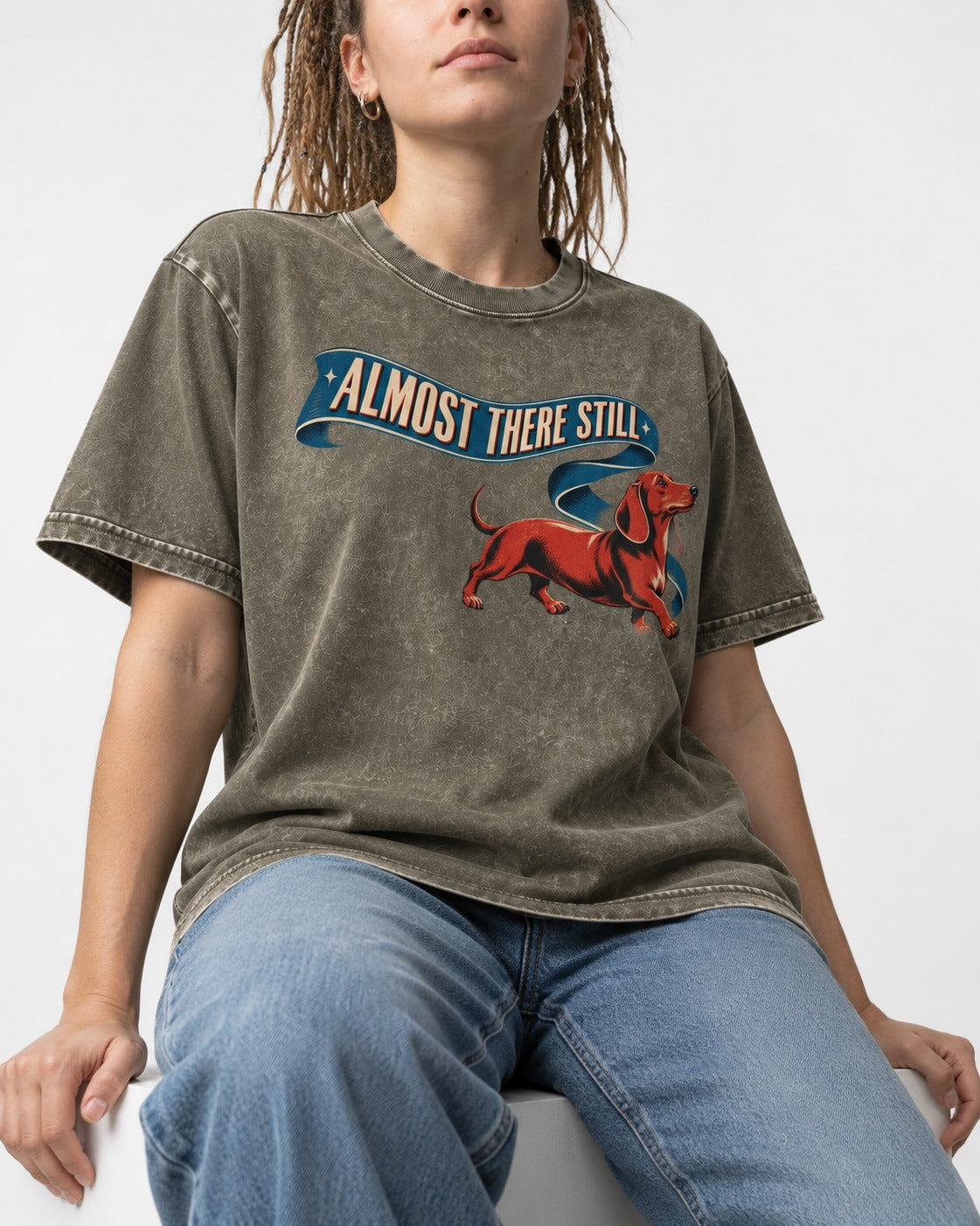 Dachshund Almost There Still Ribbon Graphic Washed Tee in Army Green, worn by a seated model