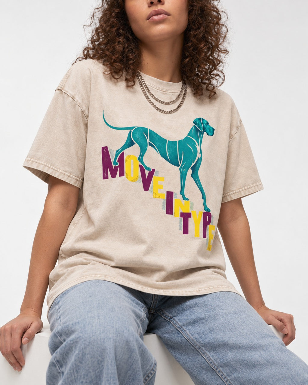 Great Dane Move in Type Washed Tee in Apricot, worn by a seated model