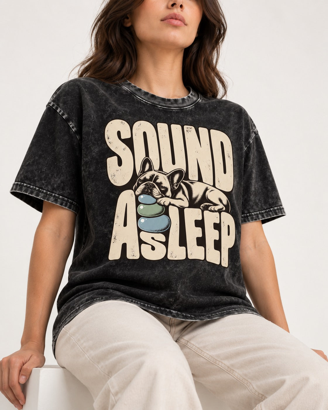 Frenchie Sound Asleep Stone Pillow Graphic Washed Tee in Black, worn by a seated model