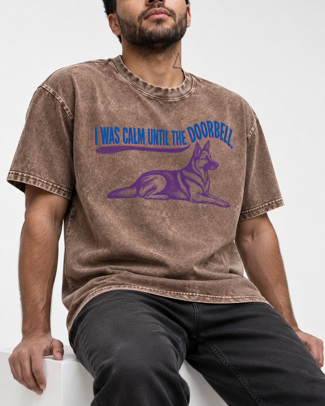 German Shepherd Dog Calm Until the Doorbell Washed Tee in Coffee, worn by a seated model