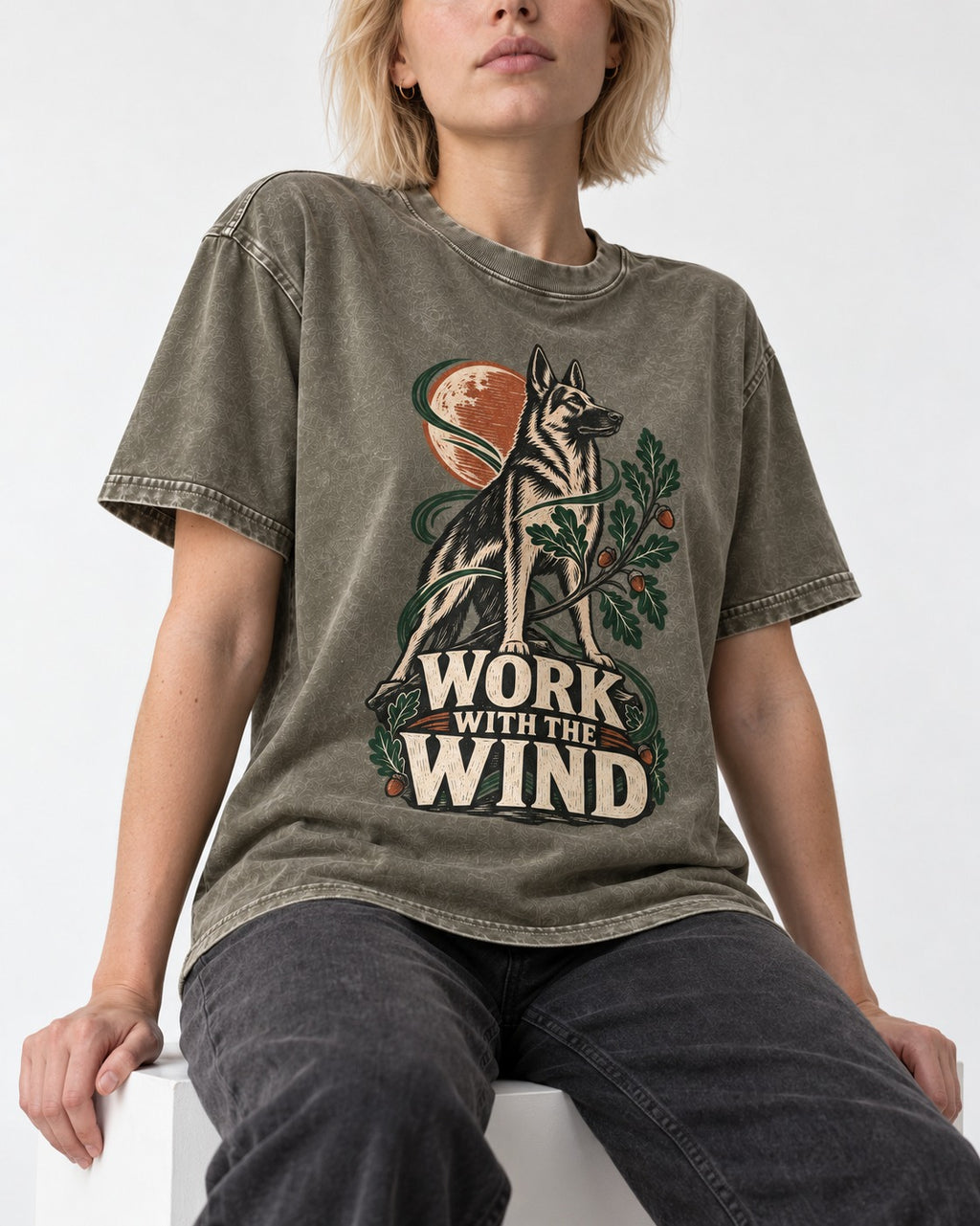 Work With The Wind Botanical Woodcut German Shepherd Dog Graphic Washed Tee in Army Green, worn by a seated model