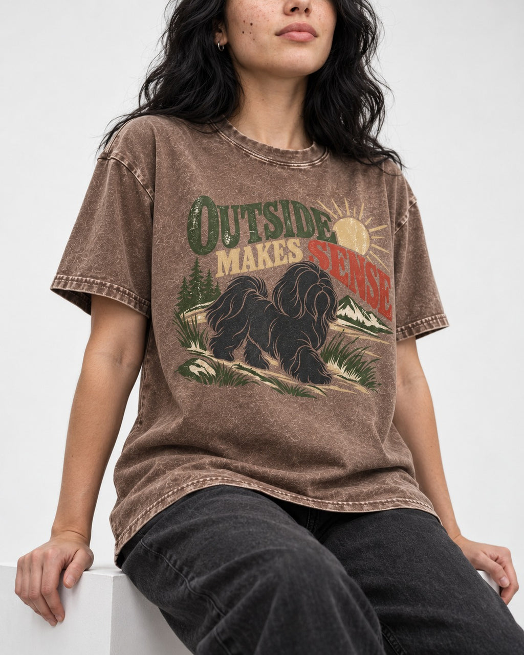Shih Tzu Outside Makes Sense Mountain Trail Graphic Washed Tee in Coffee, worn by a seated model