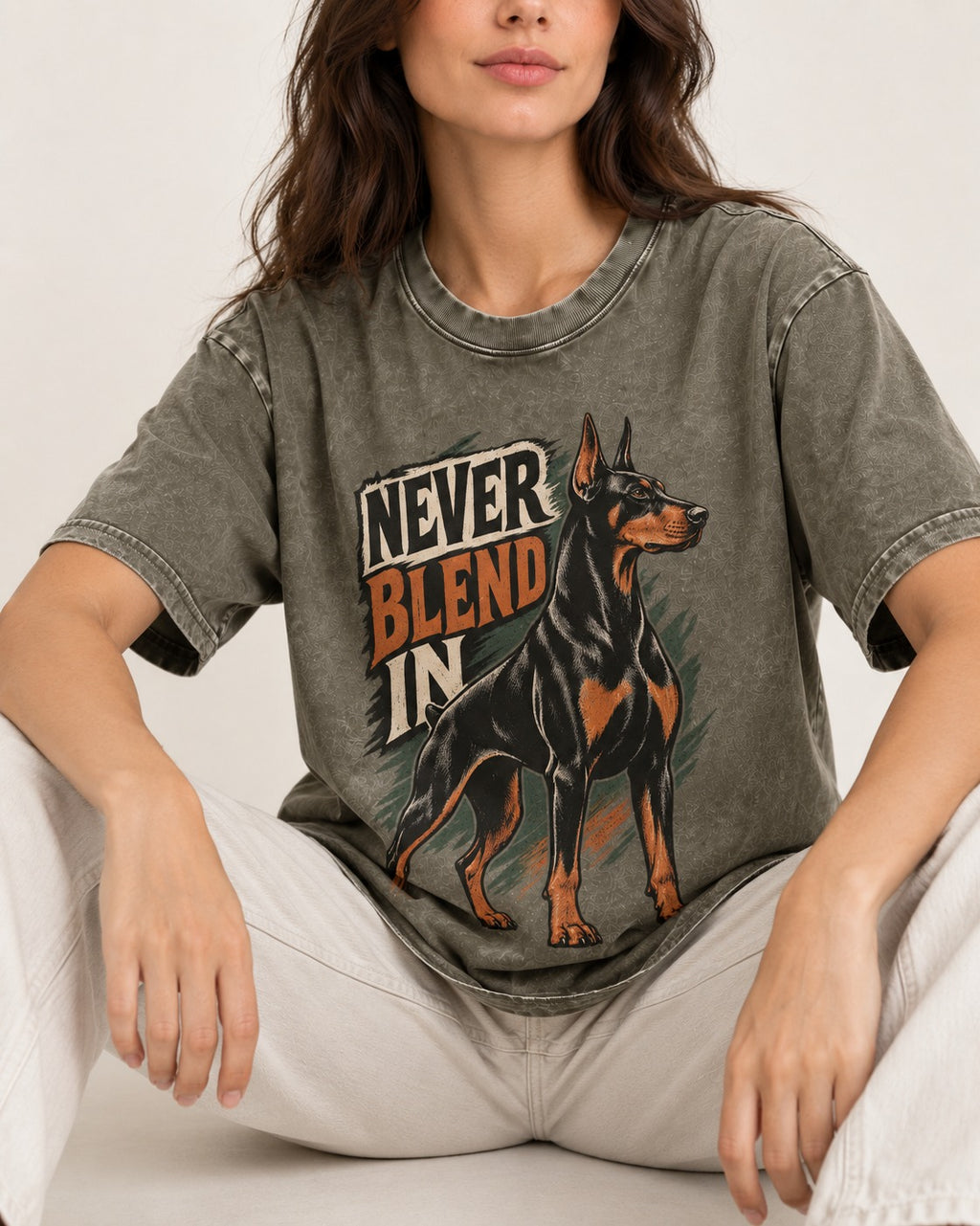 Doberman Never Blend In Brush Graphic Washed Tee in Army Green, worn by a seated model