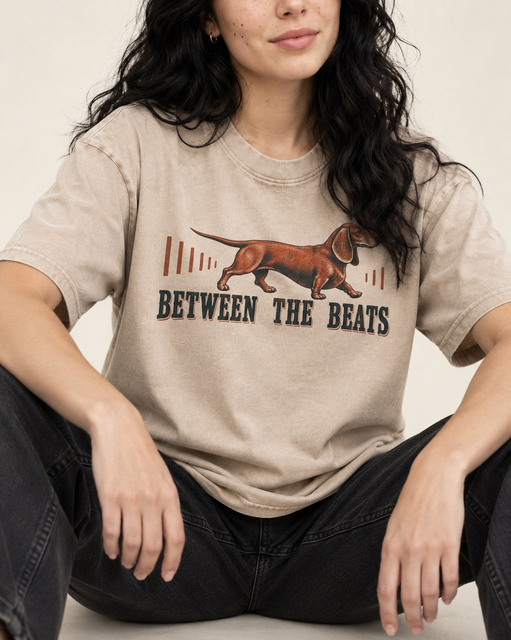 Dachshund Between the Beats Washed Tee in Apricot, worn by a seated model