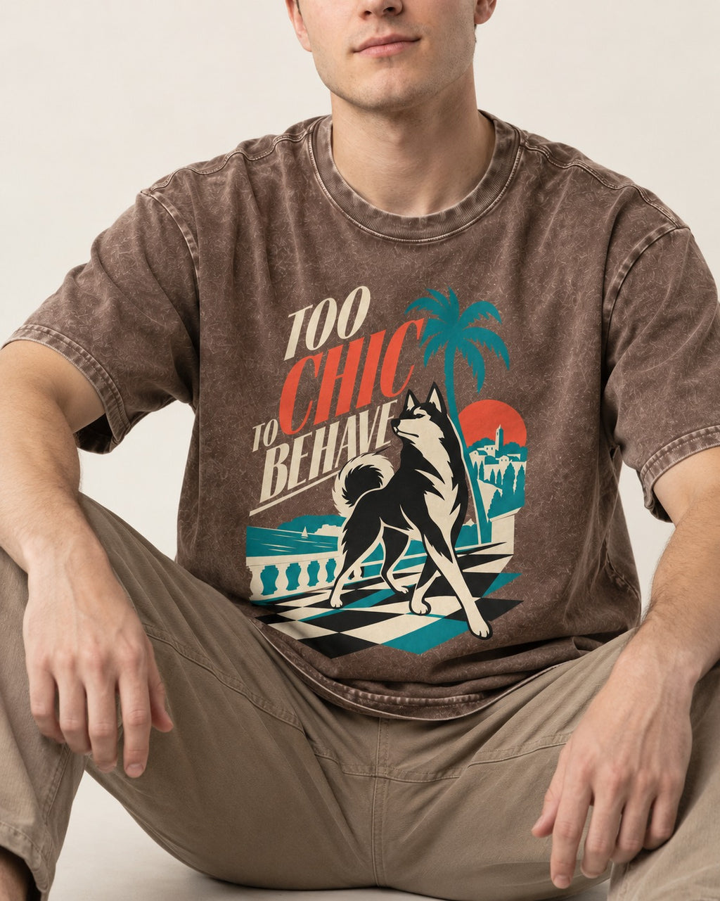 Husky Too Chic to Behave Riviera Graphic Washed Tee in Coffee, worn by a seated model