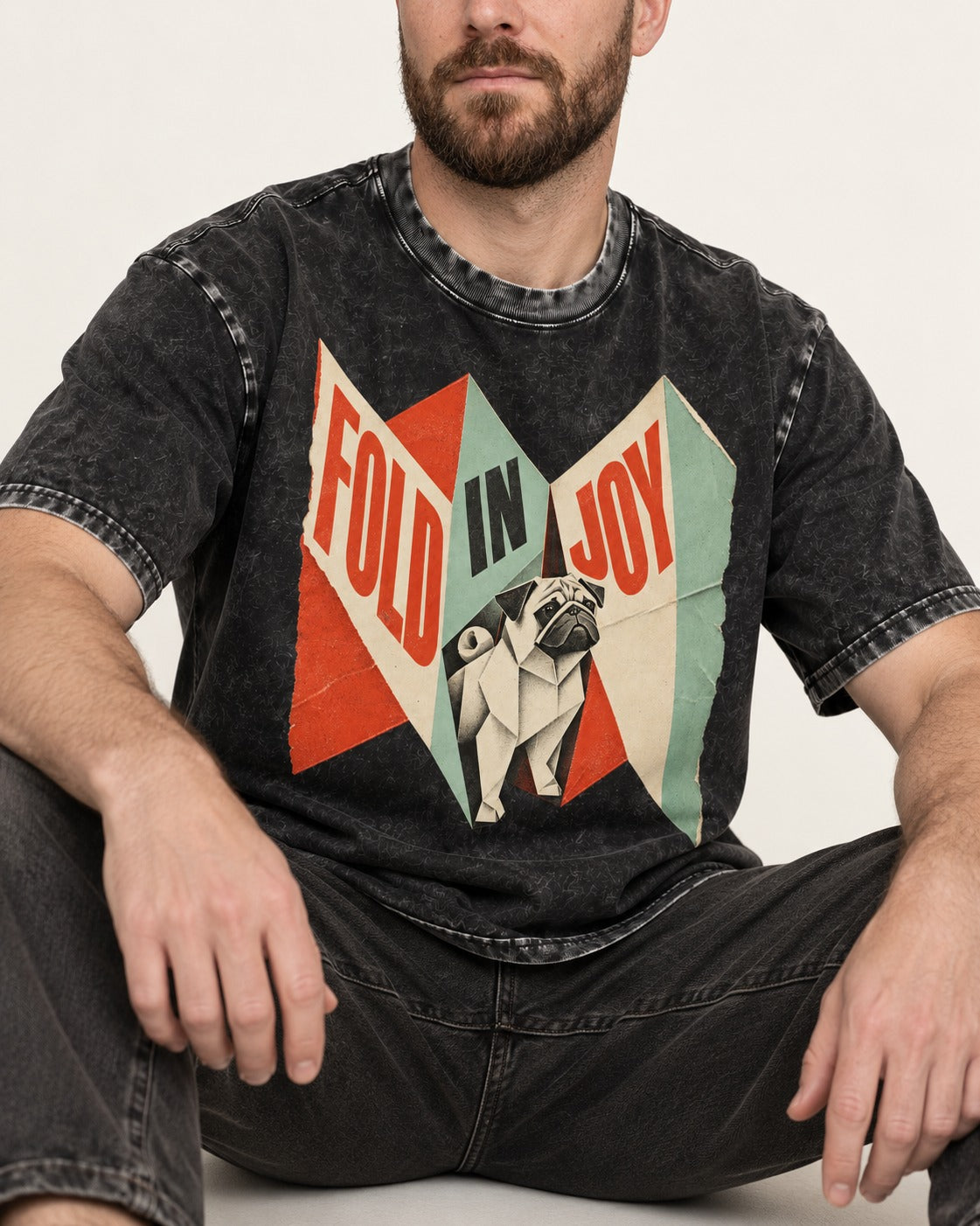 Pug Fold in Joy Geometric Poster Graphic Washed Tee in Black, worn by a seated model