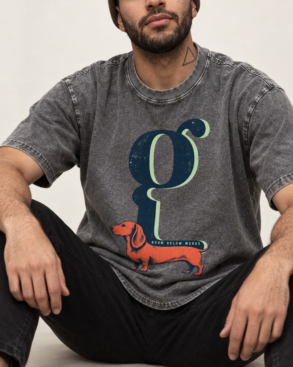 Dachshund Room Below Words Lowercase G Graphic Washed Tee in Gray, worn by a seated model
