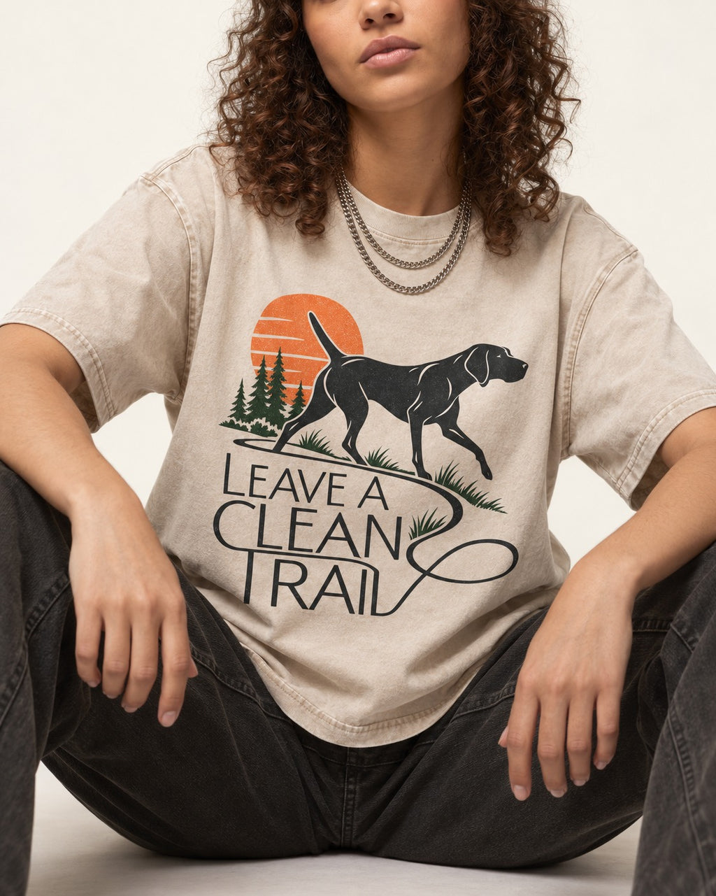 Leave a Clean Trail German Shorthaired Pointer Washed Tee in Apricot, worn by a seated model