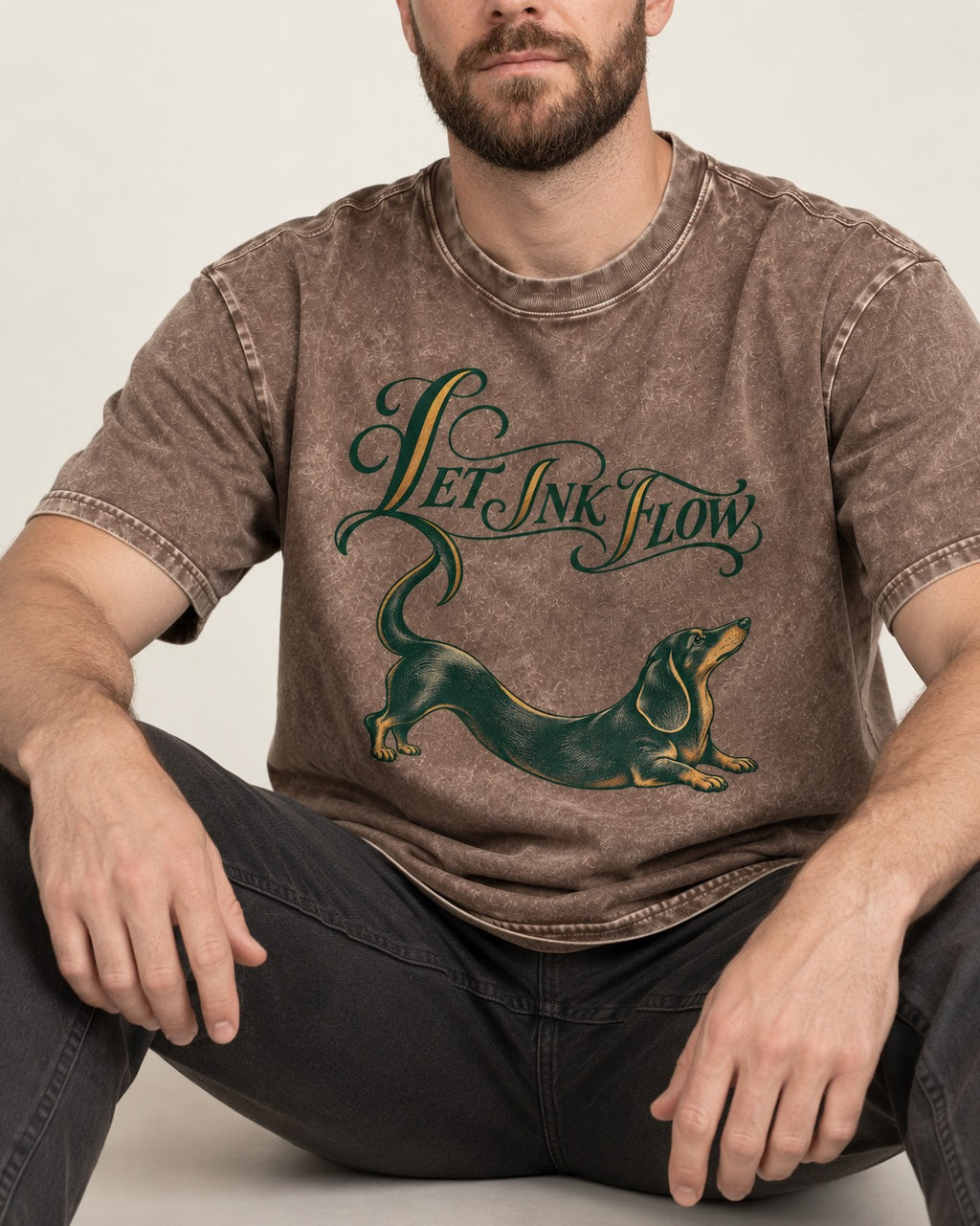 Let the Dachshund Ink Flow Washed Tee in Coffee, worn by a seated model