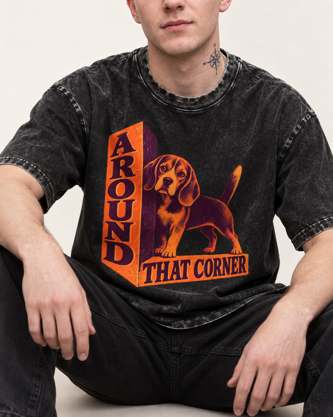 Beagle Around That Corner Graphic Washed Tee in Black, worn by a seated model