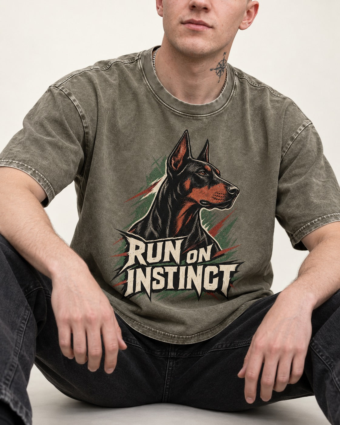 Doberman Run on Instinct Brush Slash Graphic Washed Tee in Army Green, worn by a seated model