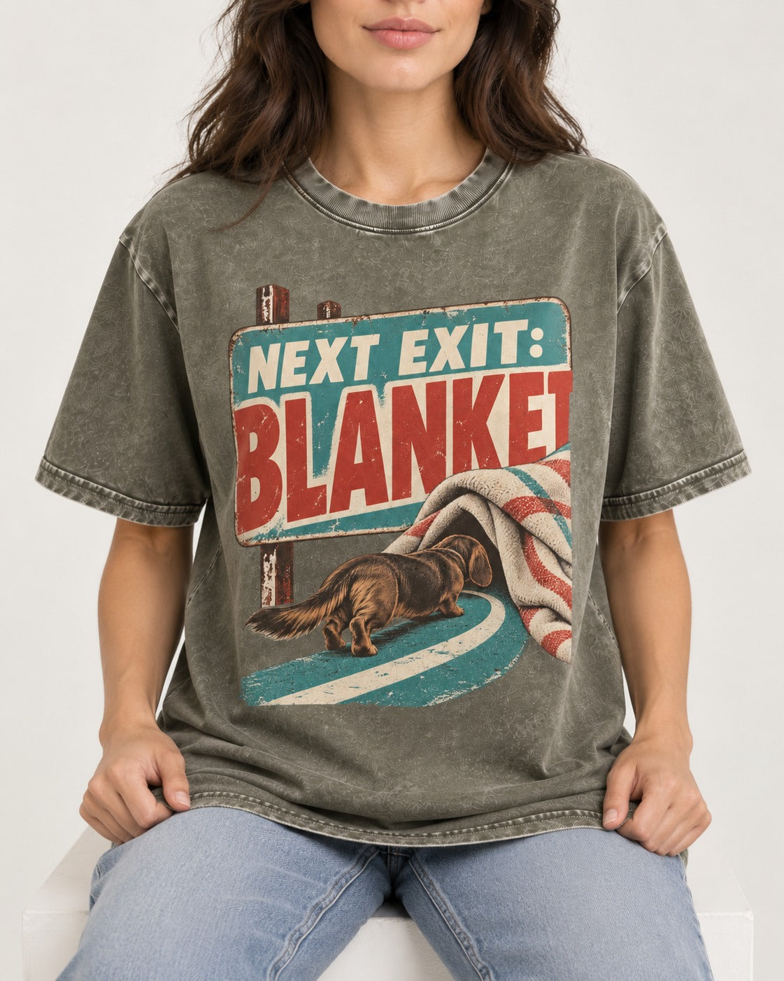 Dachshund Next Exit Blanket Road Sign Graphic Washed Tee in Army Green, worn by a seated model