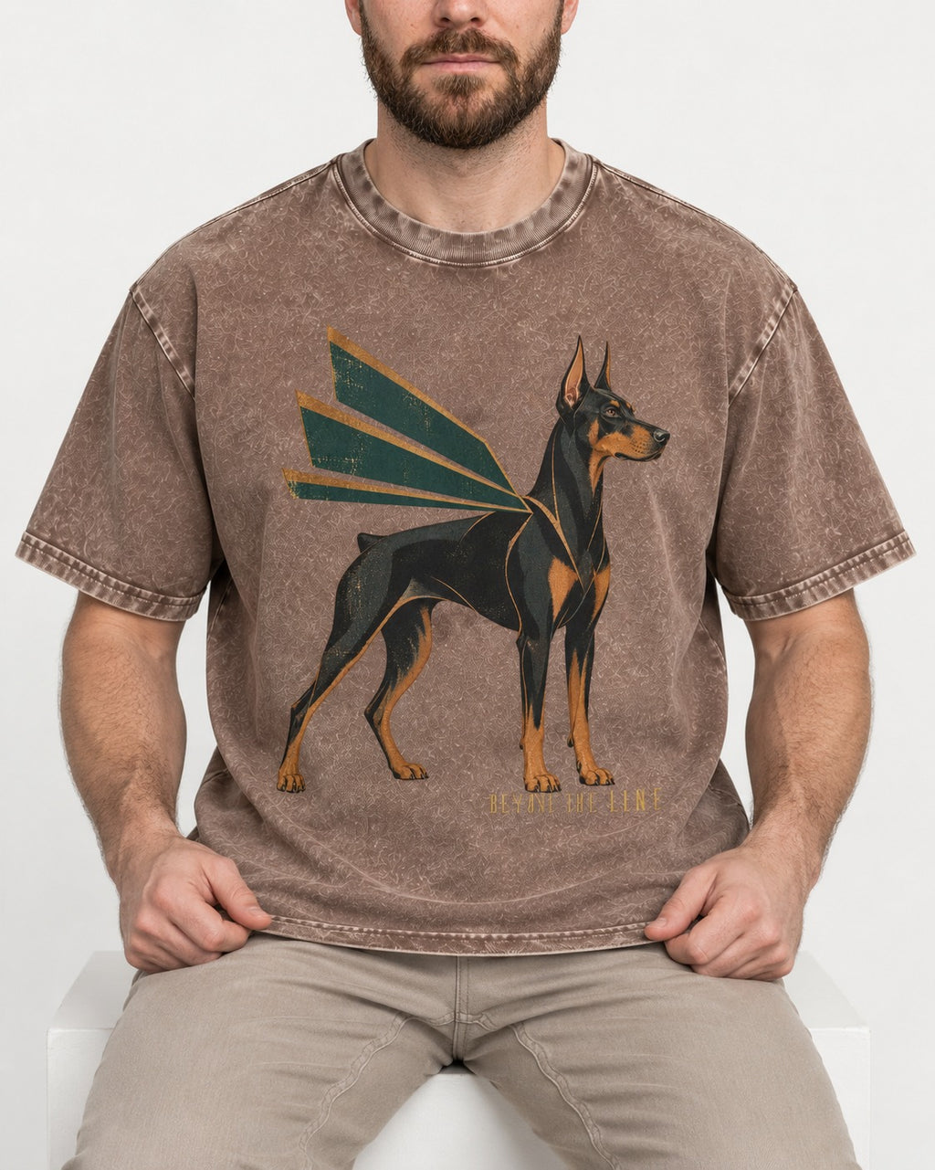 Release the Doberman Line Washed Tee in Coffee, worn by a seated model