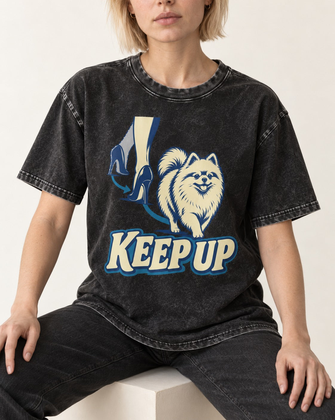 Pomeranian Keep Up High Heel Chase Graphic Washed Tee in Black, worn by a seated model