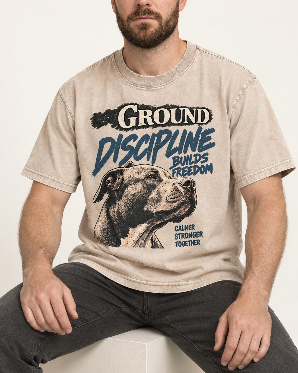 Pitbull Discipline Builds Freedom Washed Tee in Apricot, worn by a seated model