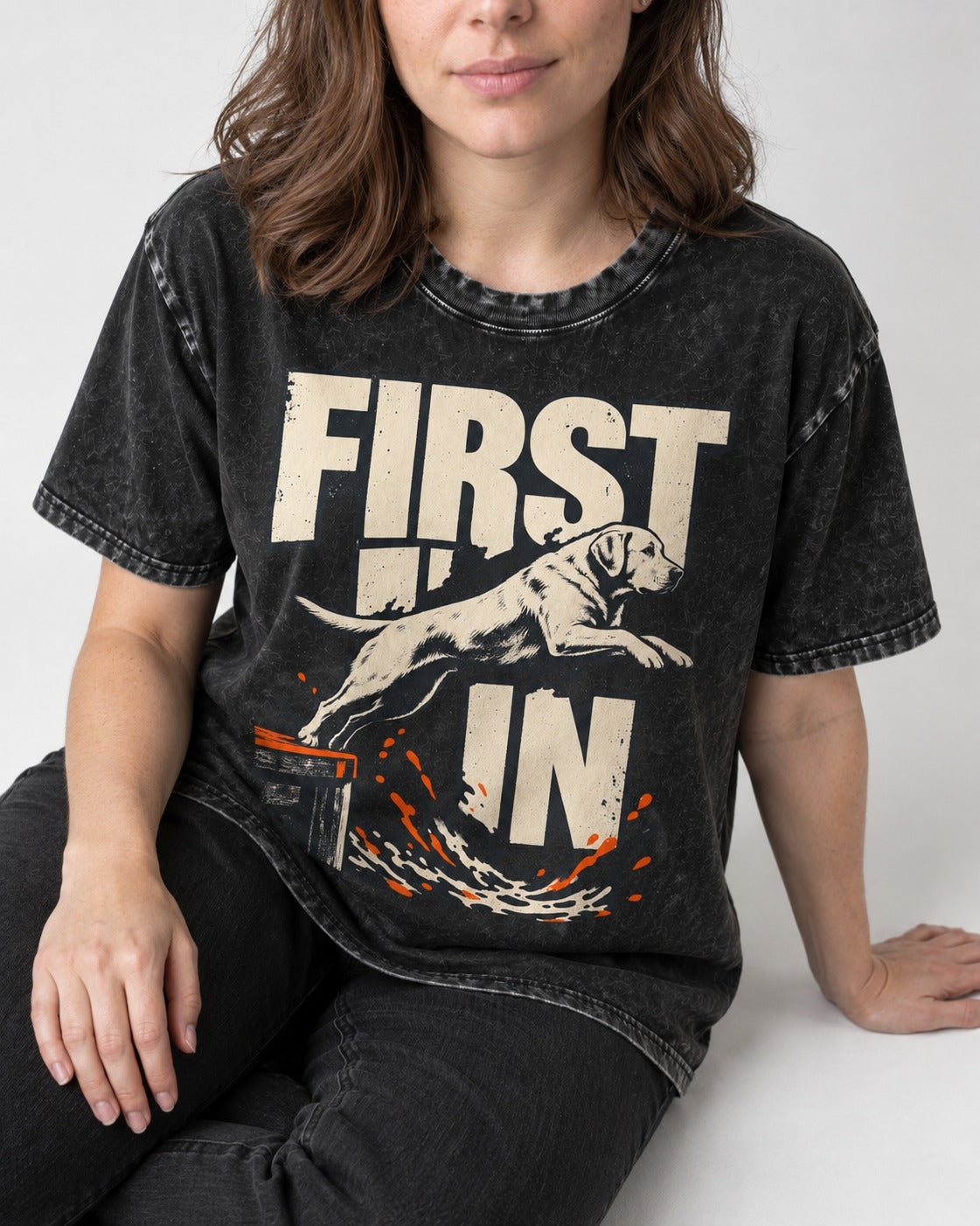 First In Dock Jump Labrador Retriever Graphic Washed Tee in Black, worn by a seated model