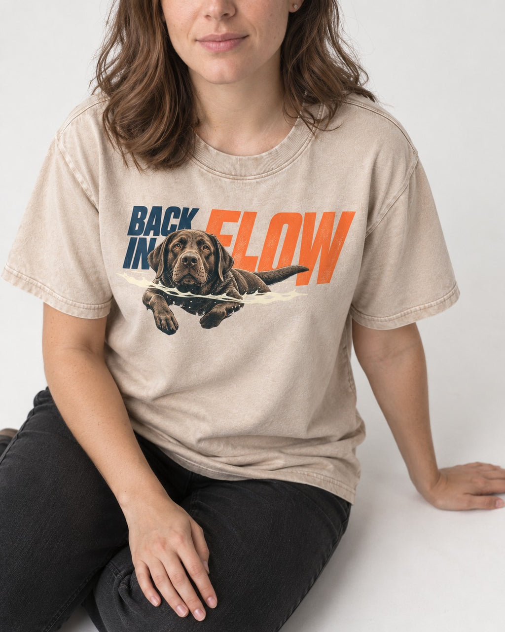 Labrador Retriever Back in Flow Washed Tee in Apricot, worn by a seated model
