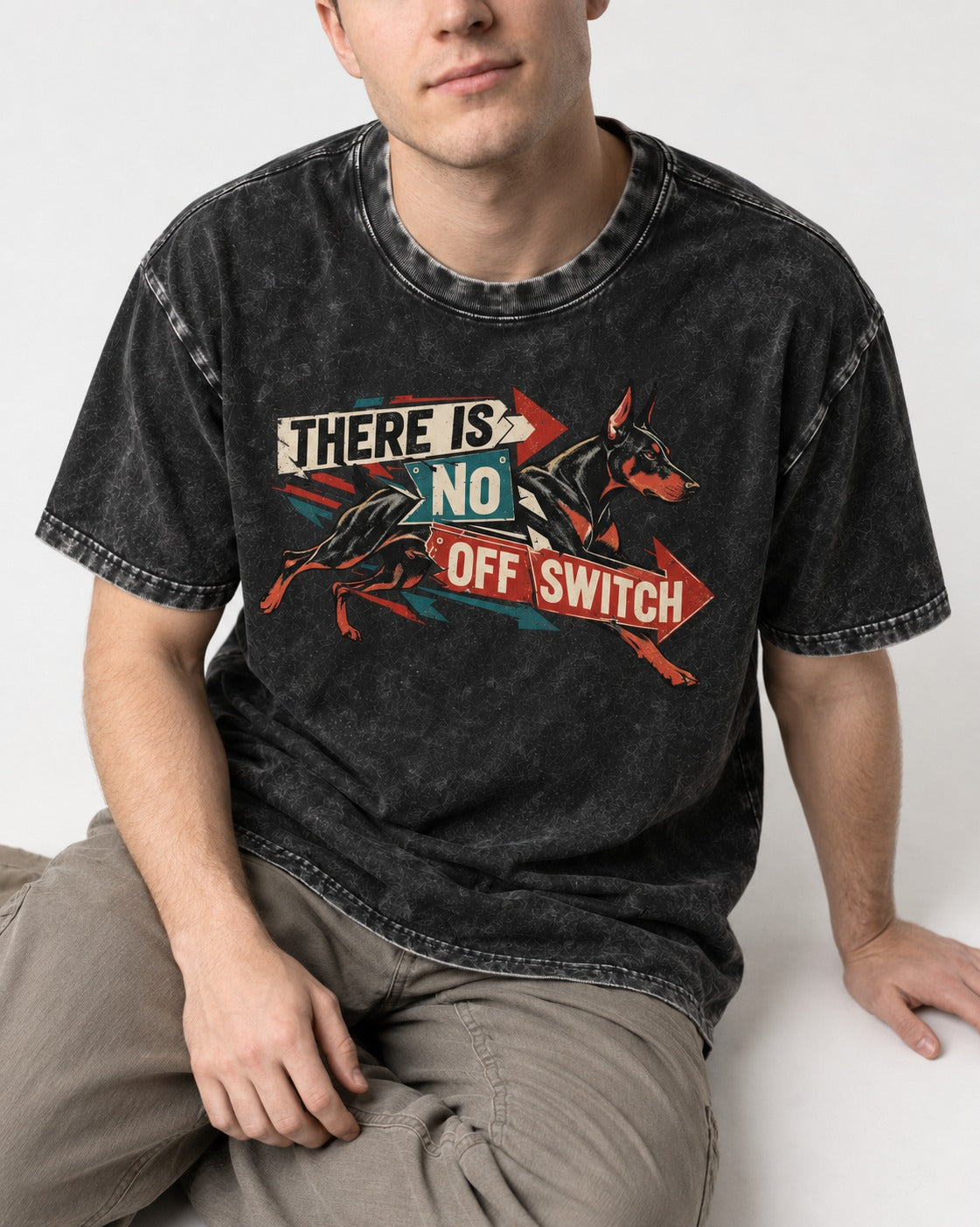 Doberman There Is No Off Switch Arrow Sprint Graphic Washed Tee in Black, worn by a seated model
