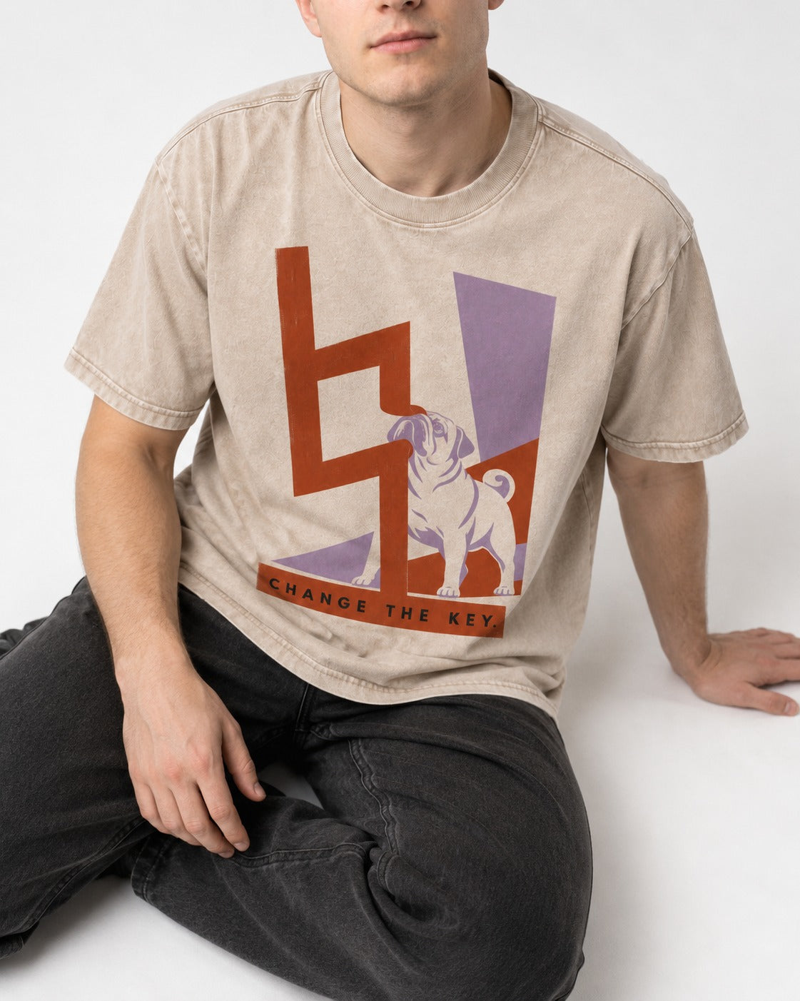 Pug Change the Key Washed Tee in Apricot, worn by a seated model