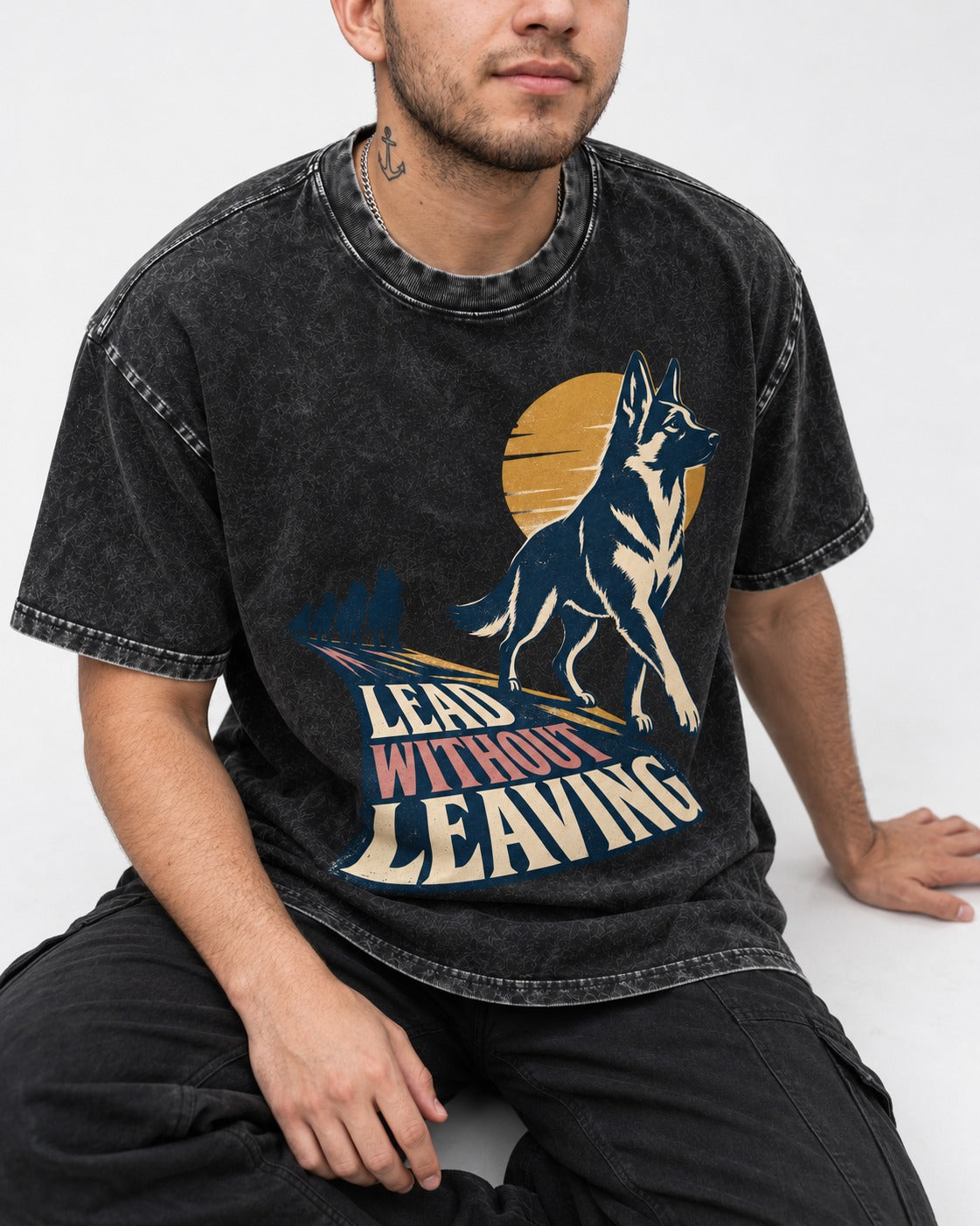 Lead Without Leaving Perspective German Shepherd Dog Graphic Washed Tee in Black, worn by a seated model