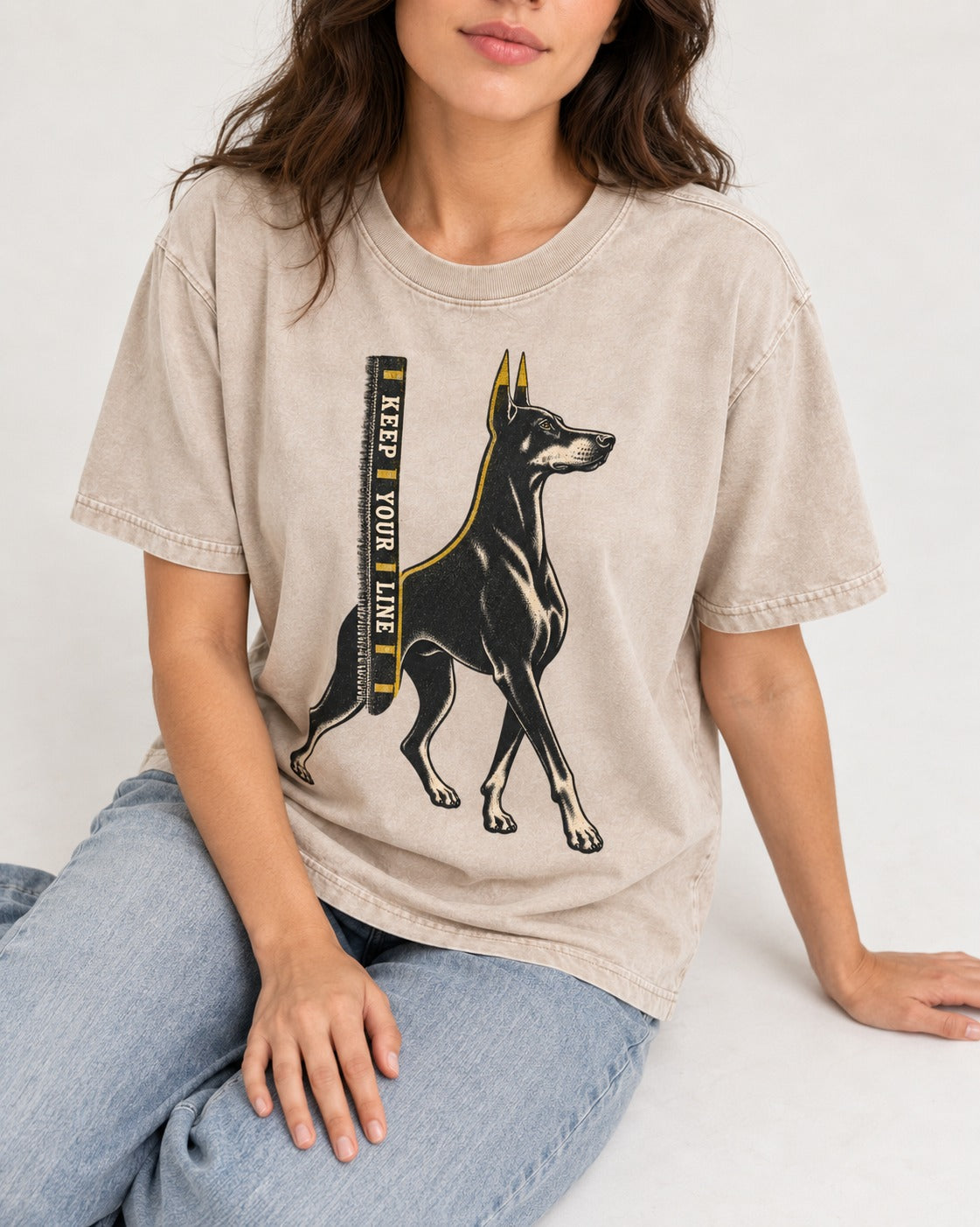 Keep Your Line Doberman Washed Tee in Apricot, worn by a seated model