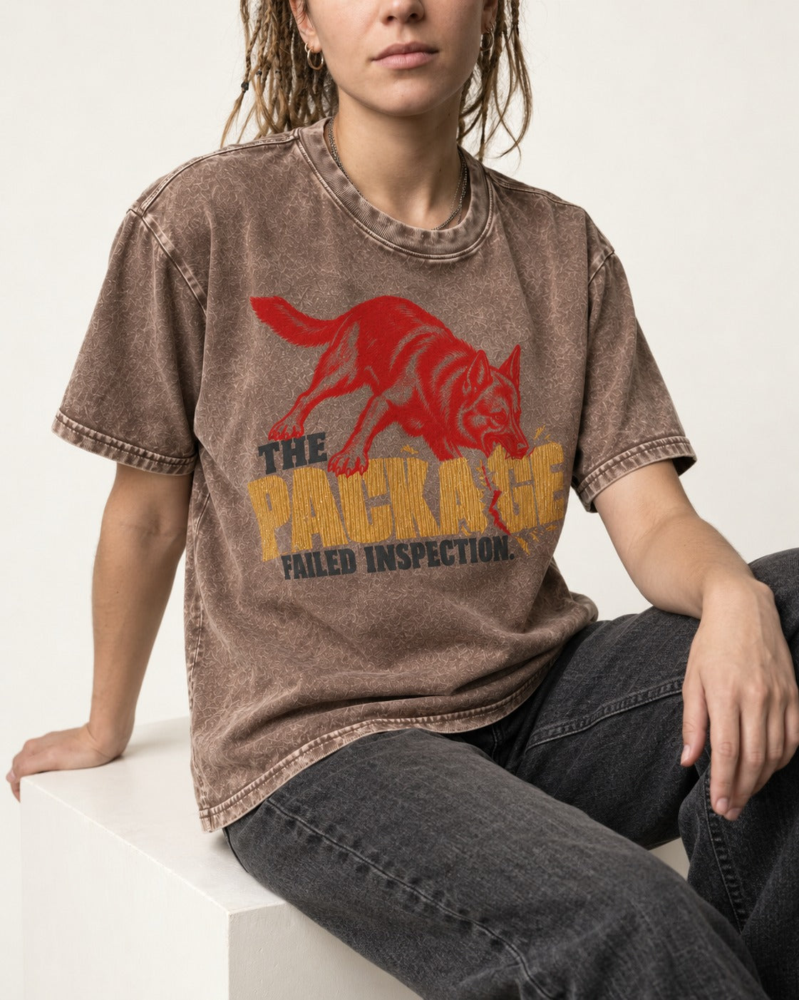 The Package Failed Inspection German Shepherd Dog Washed Tee in Coffee, worn by a seated model