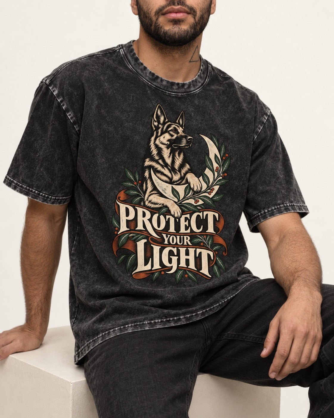Protect Your Light Moon Botanical German Shepherd Dog Graphic Washed Tee in Black, worn by a seated model