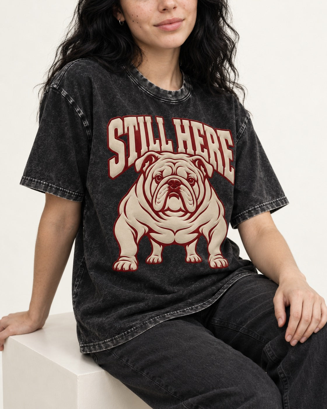 English Bulldog Still Here Collegiate Graphic Washed Tee in Black, worn by a seated model