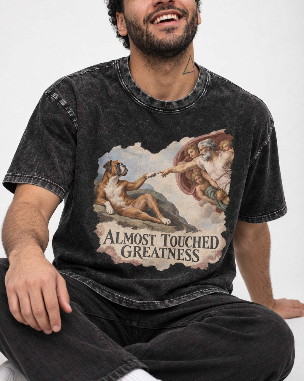 Almost Touched Greatness Boxer Creation Fresco Graphic Washed Tee in Black, worn by a seated model