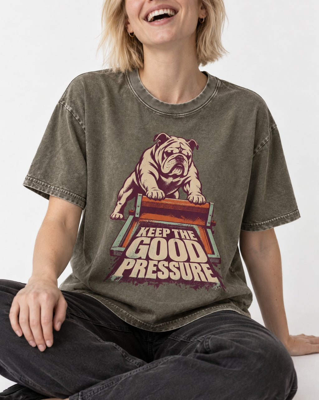 English Bulldog Keep the Good Pressure Printing Press Graphic Washed Tee in Army Green, worn by a seated model