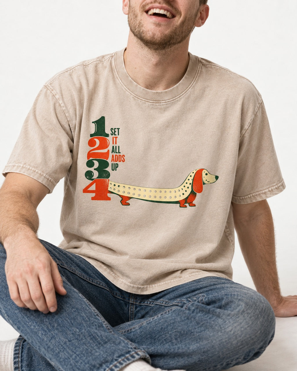 Dachshund Adds Up Washed Tee in Apricot, worn by a seated model