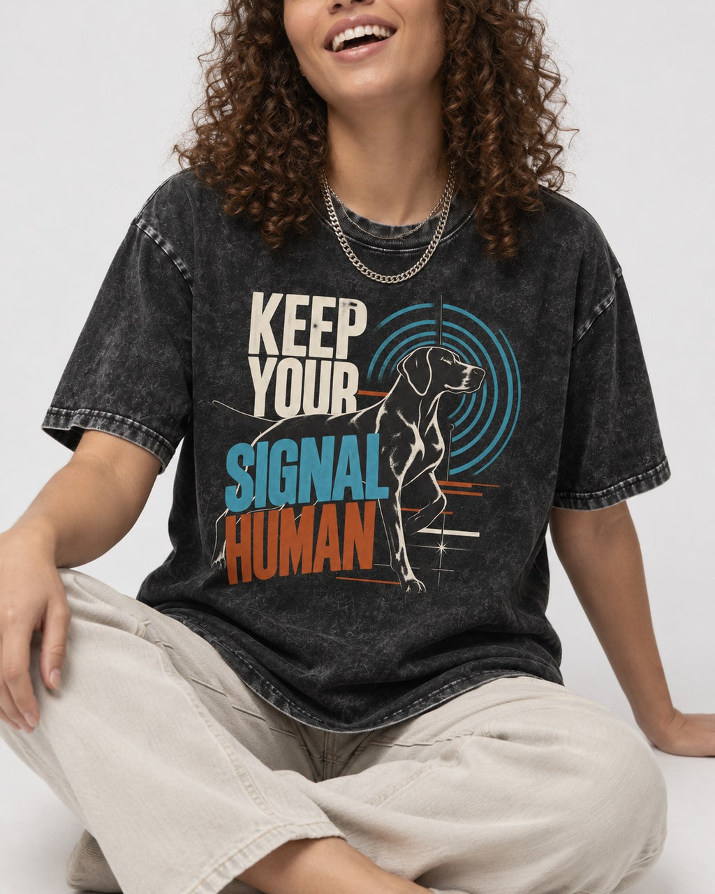 German Shorthaired Pointer Keep Your Signal Human Broadcast Graphic Washed Tee in Black, worn by a seated model