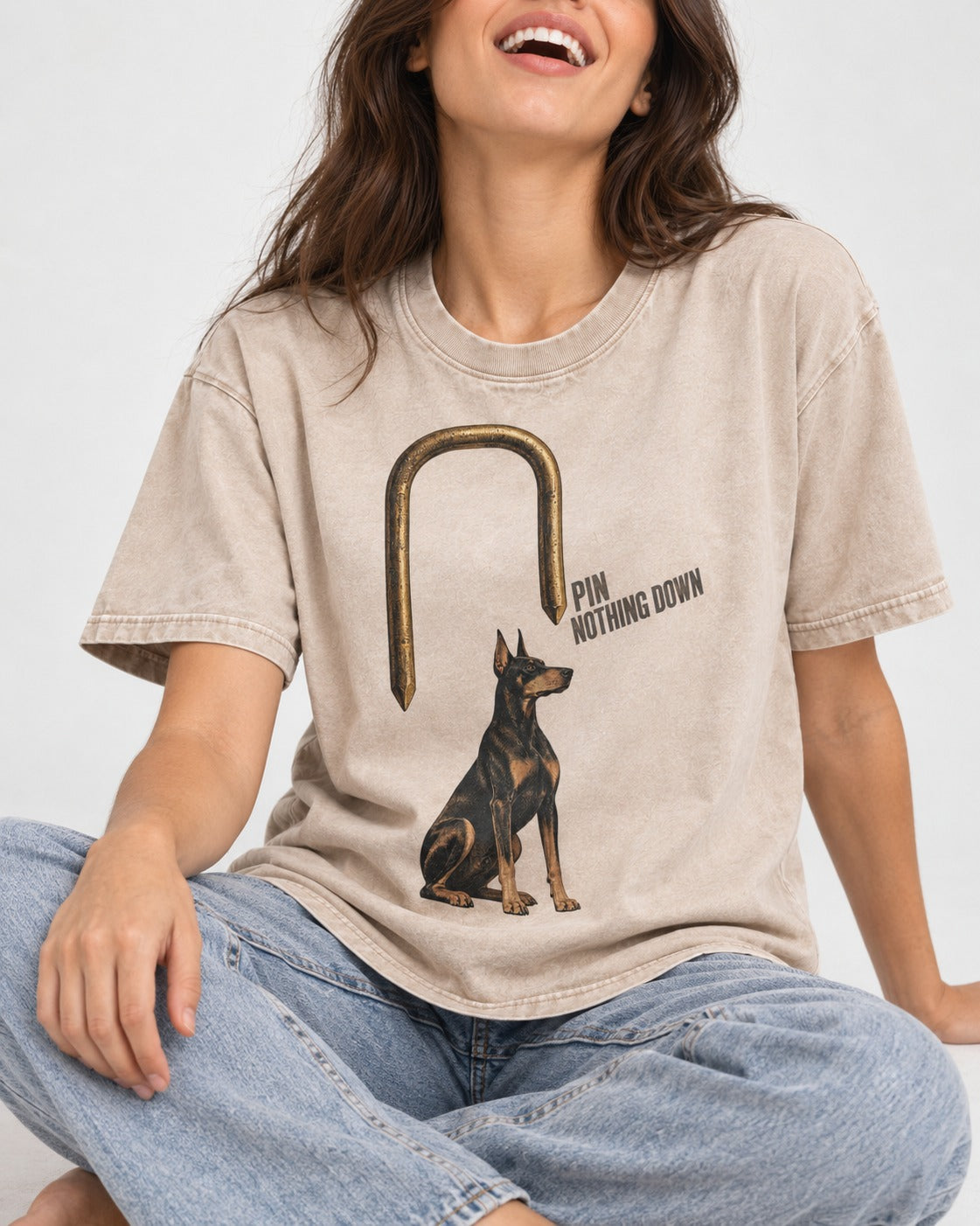 Nothing Pins Doberman Down Washed Tee in Apricot, worn by a seated model
