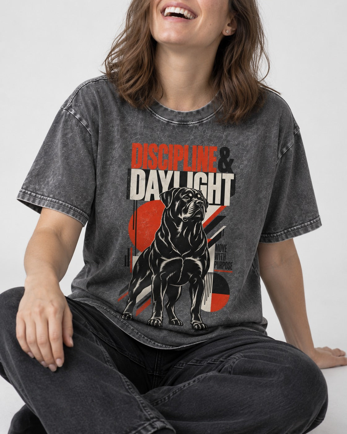 Discipline and Daylight Rottweiler Move With Purpose Washed Tee in Gray, worn by a seated model