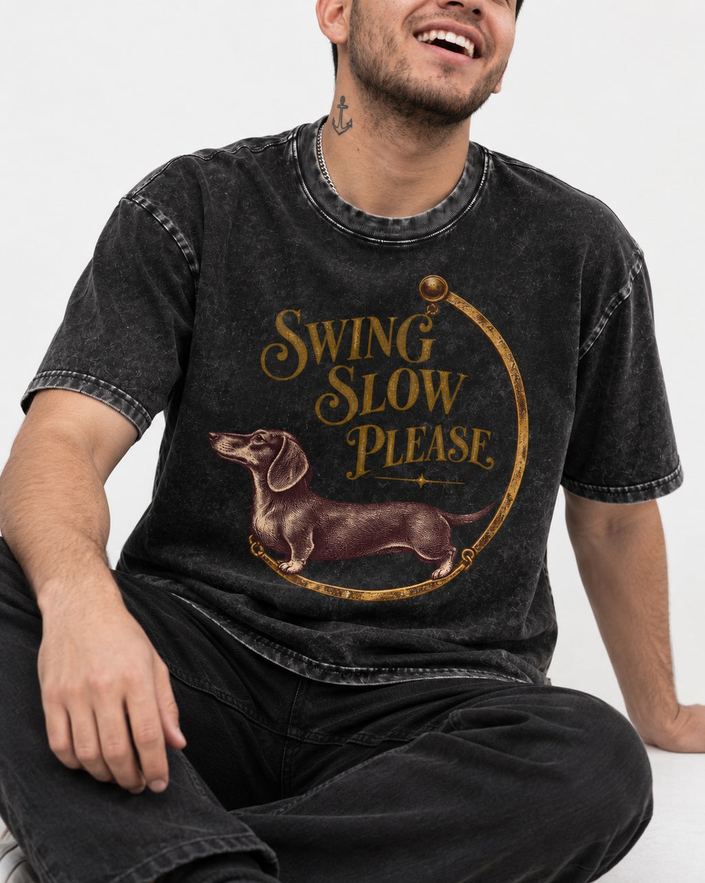 Dachshund Swing Slow Please Necklace Frame Graphic Washed Tee in Black, worn by a seated model