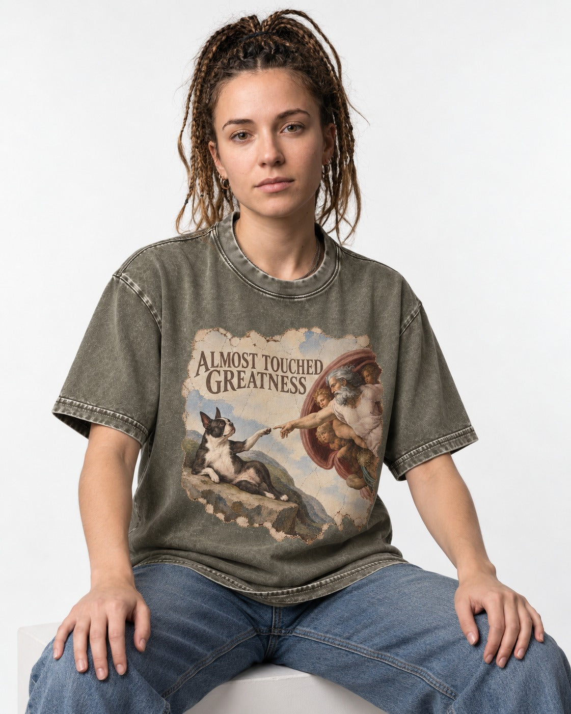 Almost Touched Greatness Boston Terrier Renaissance Parody Washed Tee in Army Green, worn by a seated model