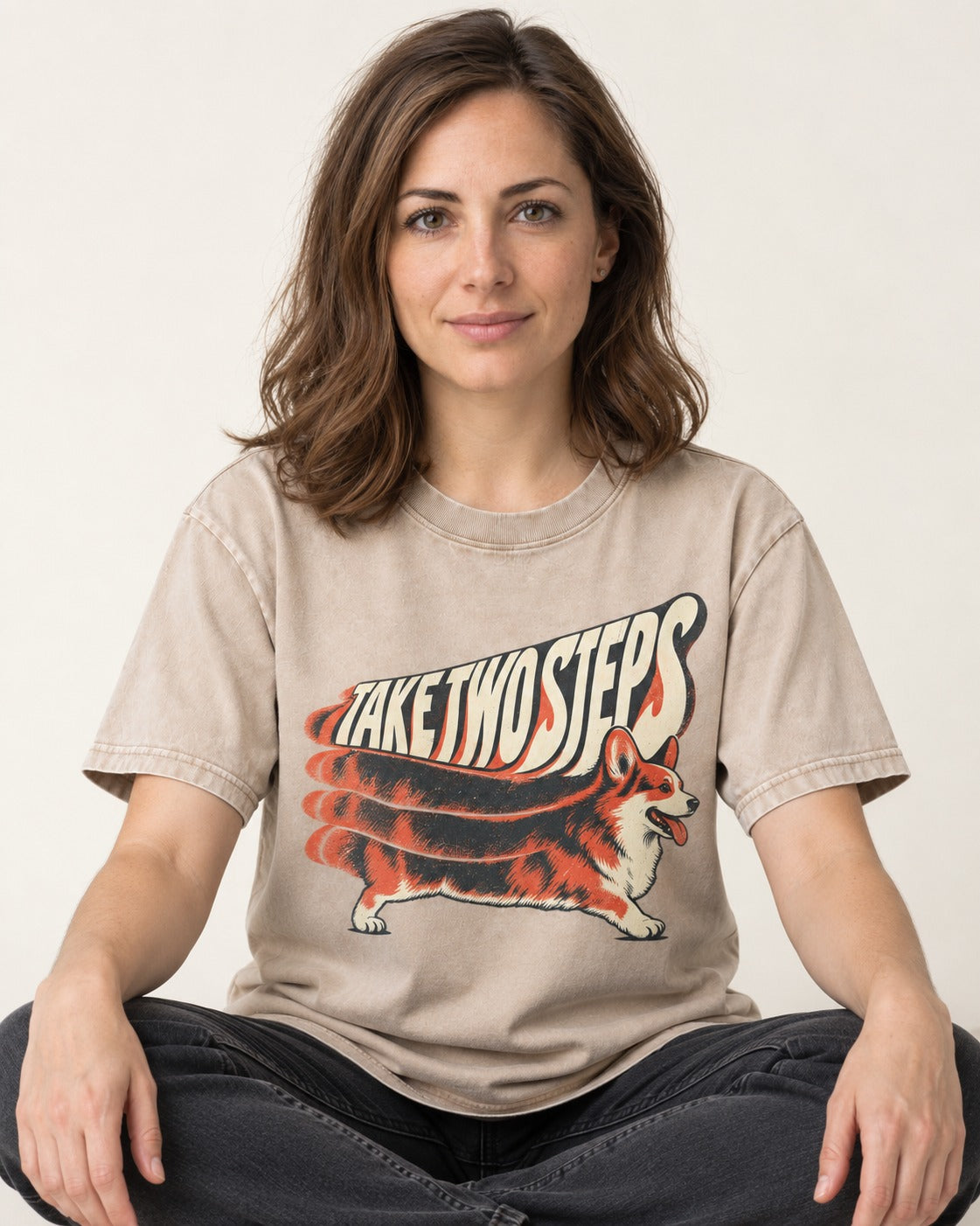 Corgi Take Two Steps Motion Trail Graphic Washed Tee in Apricot, worn by a seated model