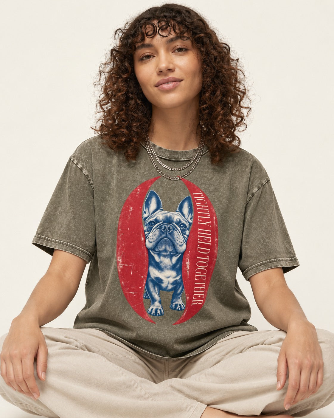Frenchie Tightly Held Together Red Oval Graphic Washed Tee in Army Green, worn by a seated model