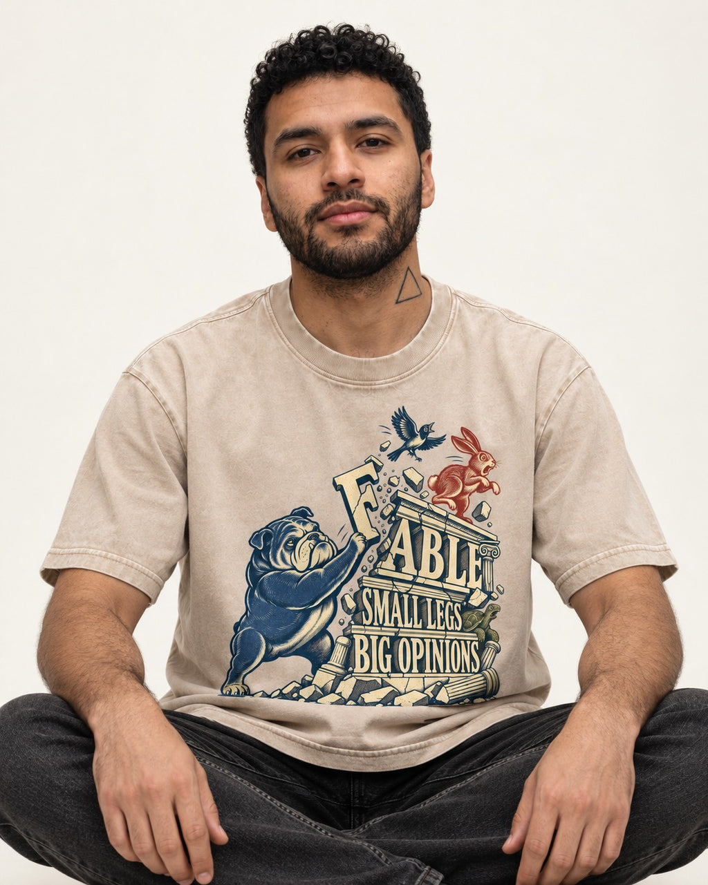 Small Legs Big Opinions English Bulldog Washed Tee in Apricot, worn by a seated model