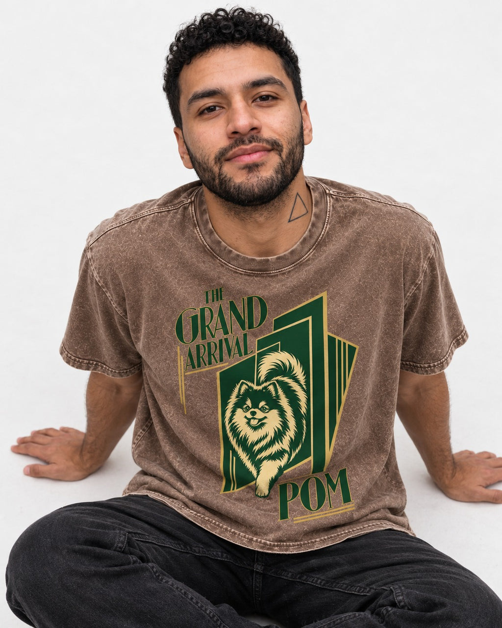 The Grand Arrival Pomeranian Washed Tee in Coffee, worn by a seated model