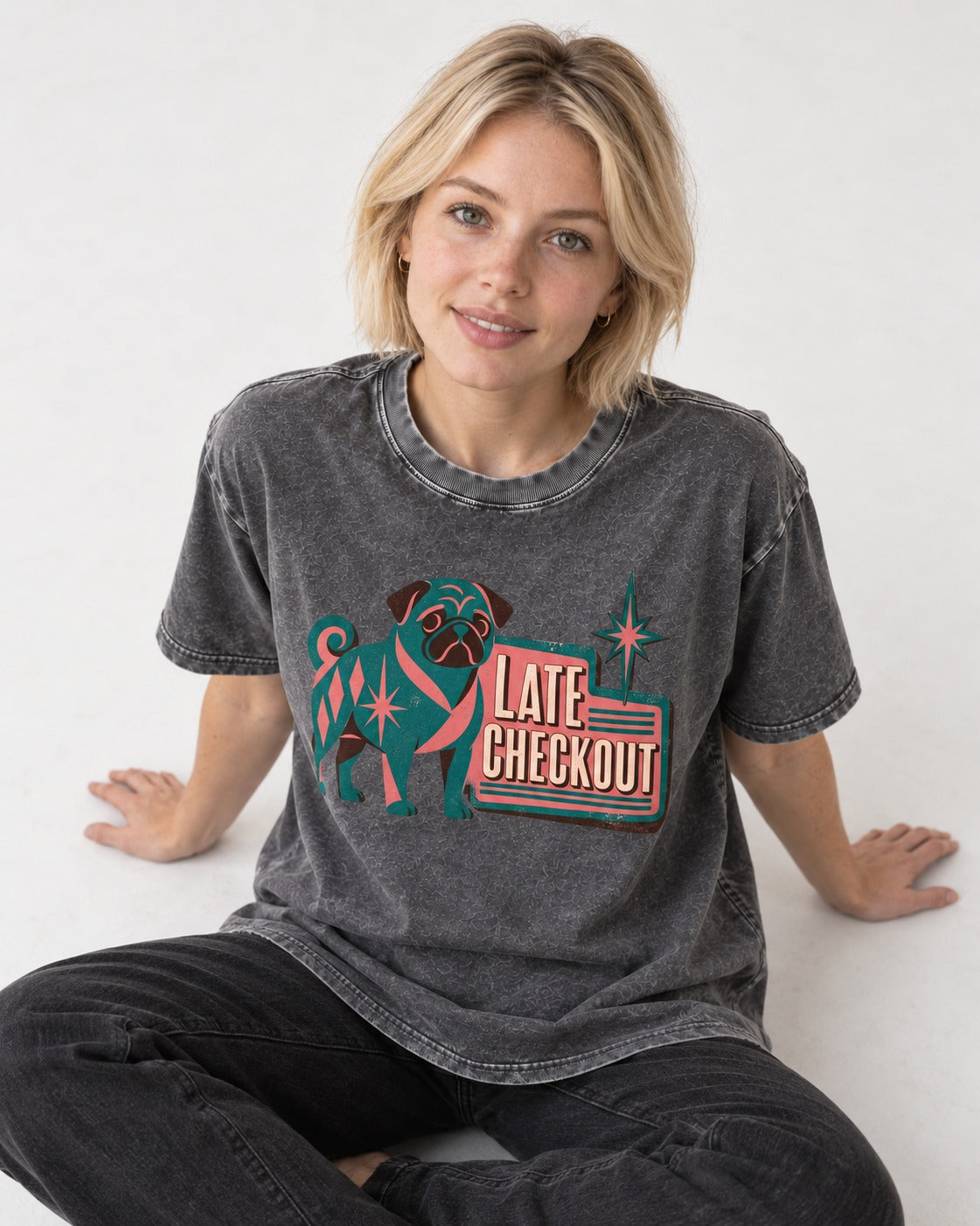 Pug's Late Checkout Washed Tee in Gray, worn by a seated model