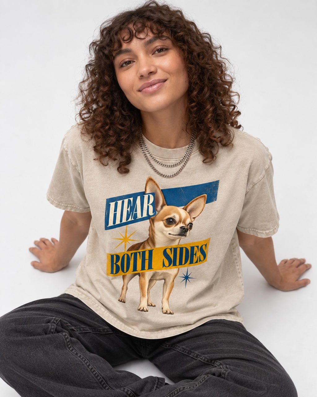 Chihuahua Hear Both Sides Banner Graphic Washed Tee in Apricot, worn by a seated model