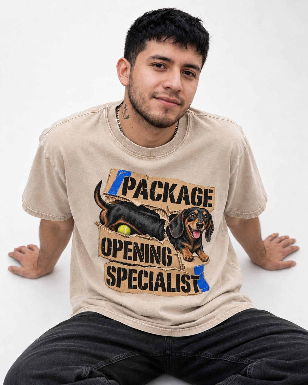 Dachshund Package Opening Specialist Washed Tee in Apricot, worn by a seated model