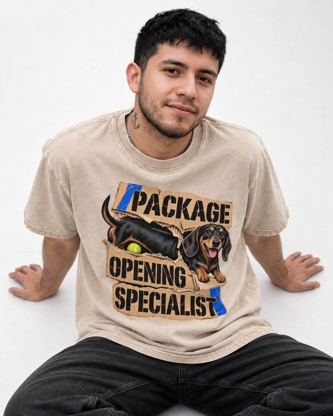 Dachshund Package Opening Specialist Washed Tee in Apricot, worn by a seated model