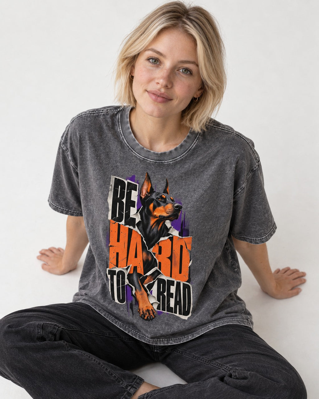 Doberman Be Hard to Read Torn Poster Graphic Washed Tee in Gray, worn by a seated model