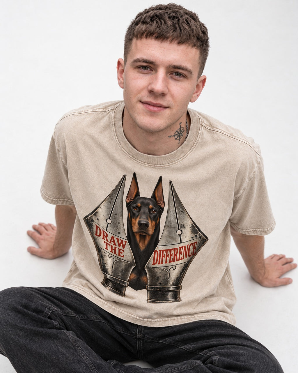 Doberman Draw the Difference Washed Tee in Apricot, worn by a seated model