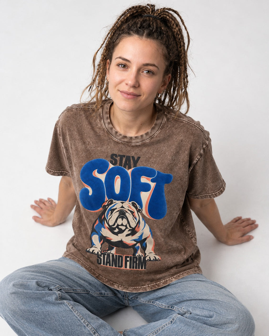 Stay Soft Stand Firm English Bulldog Washed Tee in Coffee, worn by a seated model